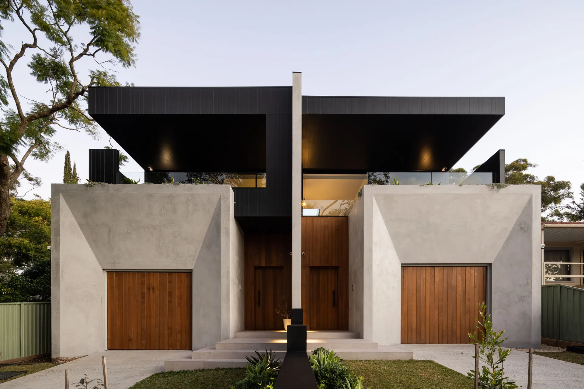 Architect-designed attached duplex in Gymea, Sydney – rendered facade with timber garage doors, built by JBuild Construction Group